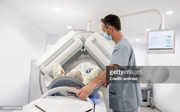 senior patient getting a ct scan at the hospital - cat scan machine stock pictures, royalty-free photos & images