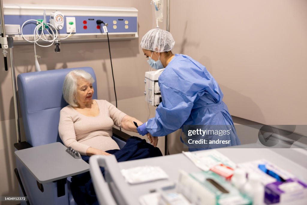 Infirmière préparant une patiente atteinte de cancer à sa chimiothérapie à l’hôpital