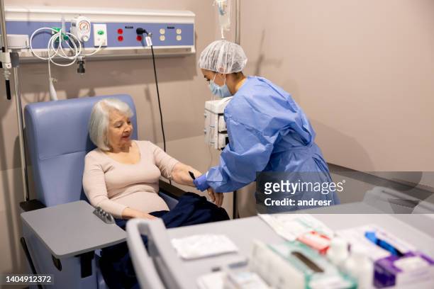 infermiera che prepara un malato di cancro per la chemioterapia in ospedale - trattamento di bellezza foto e immagini stock