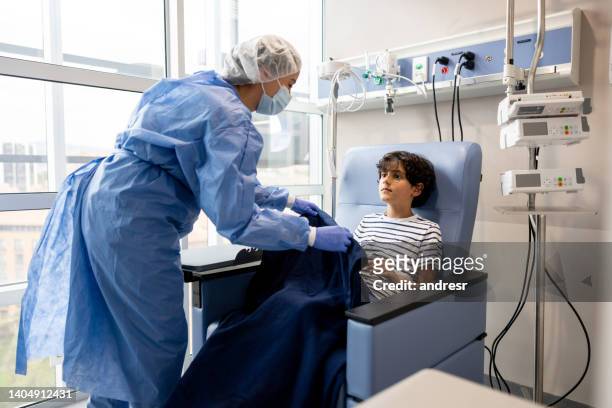 enfermeira deixando um jovem paciente confortável enquanto faz sua quimioterapia - infused - fotografias e filmes do acervo