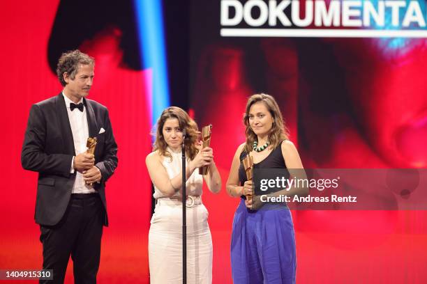 Frank Mueller, Guevara Namer and Antonia Kilian, winners of the Award for Best Documentary Film for The Other Side of the River, react on stage the...