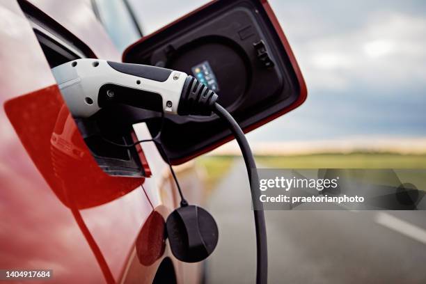 electric car is charging on the road - station service france stock pictures, royalty-free photos & images