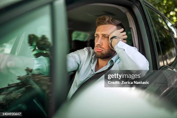 serious businessman driving a car ,stuck in traffic jam - file stockfoto's en -beelden
