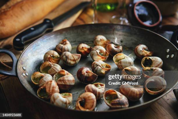 zubereitung von französischen schnecken mit kräuterbutter - französische küche stock-fotos und bilder