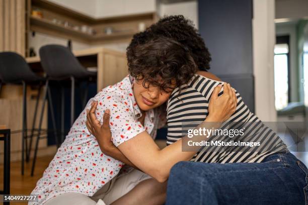 two friends sharing a hard moment by hugging - consoling stock pictures, royalty-free photos & images