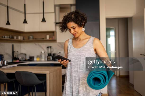 mujer preparándose para su práctica de yoga - 40 44 años fotografías e imágenes de stock