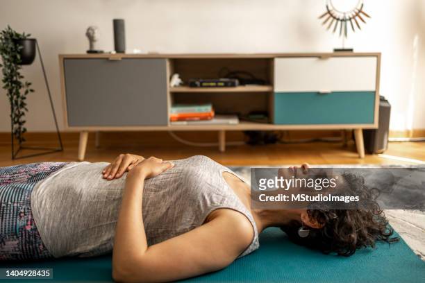 woman doing breathing exercises - lying bildbanksfoton och bilder