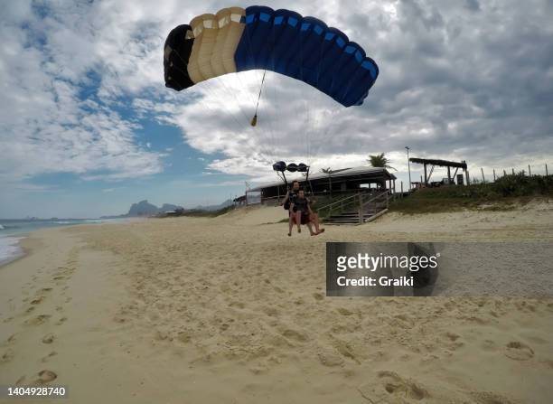 skydive tandem landing at the beach - barra da tijuca stockfoto's en -beelden