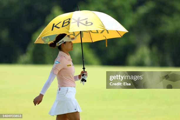 In Gee Chun of South Korea walks under an umbrella on the eighth hole during the second round of the KPMG Women's PGA Championship at Congressional...