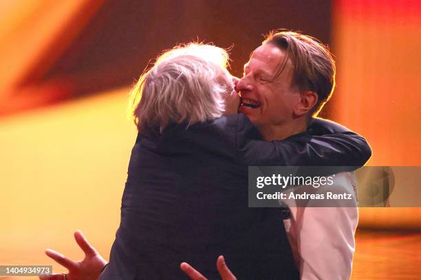Andreas Dresen embraces Alexander Scheer, winner of the Award for Best Supporting Actor, on stage the 72nd Lola - German Film Award show at Palais am...