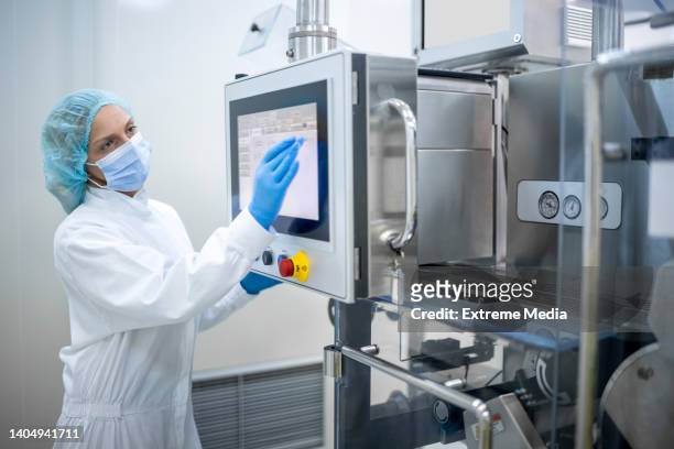 woman wearing proper equipment seen in pharmaceutical manufacturing - hygiene 個照片及圖片檔