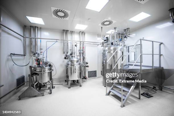 an empty laboratory with three big machines in a pharmaceutical factory - farmaceutische-fabriek stockfoto's en -beelden