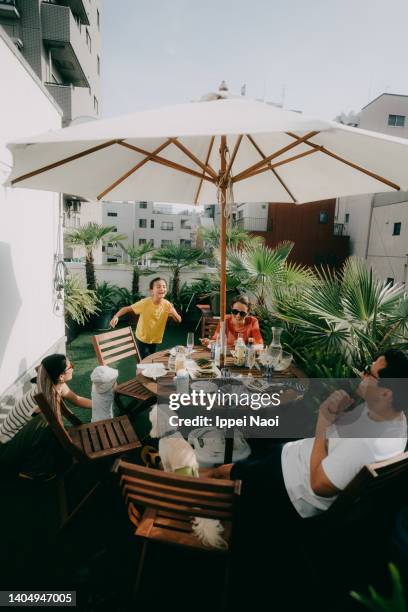 family having fun on rooftop terrace in city, tokyo - in a japanese garden stock-fotos und bilder