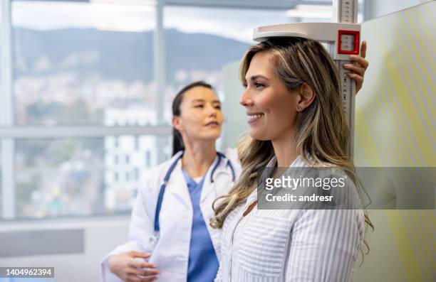 doctor performing a medical exam on a woman in her office - high up imagens e fotografias de stock