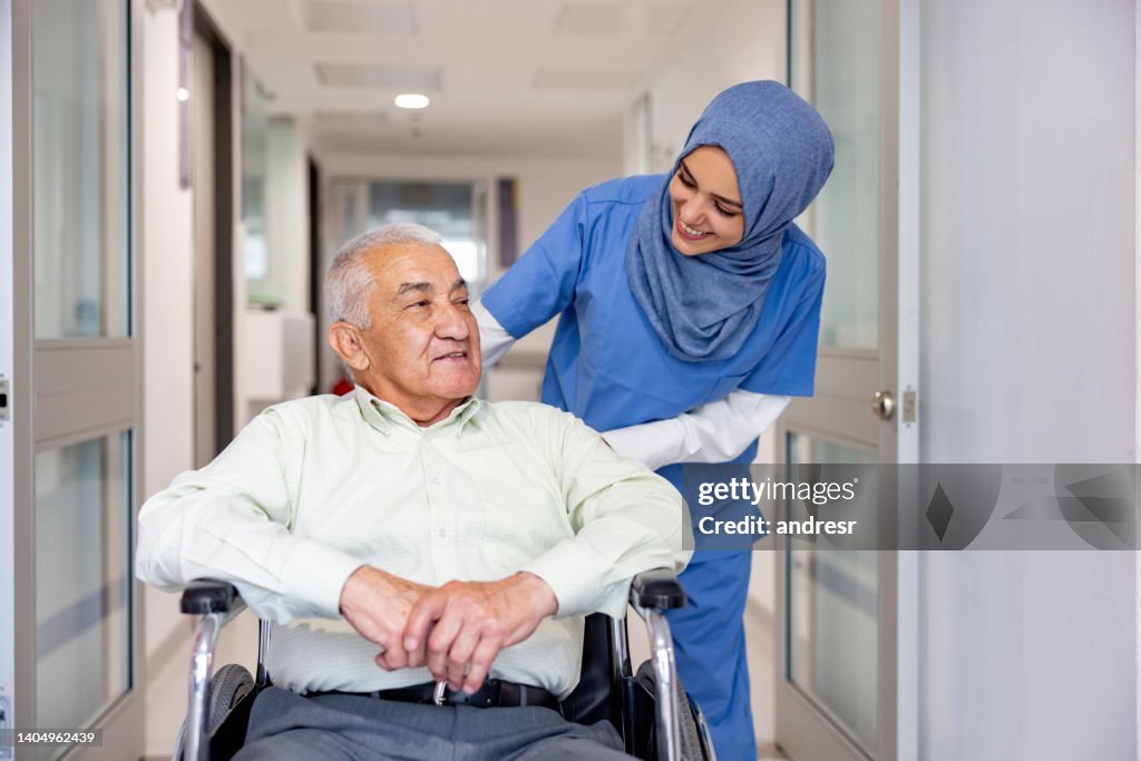 Une infirmière musulmane s’occupe d’un patient âgé en fauteuil roulant
