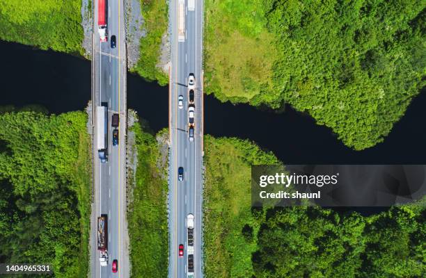 highway traffic crosses river - truck birds eye stock pictures, royalty-free photos & images