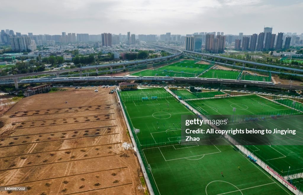 Aerial photography of precious football fields in crowded city