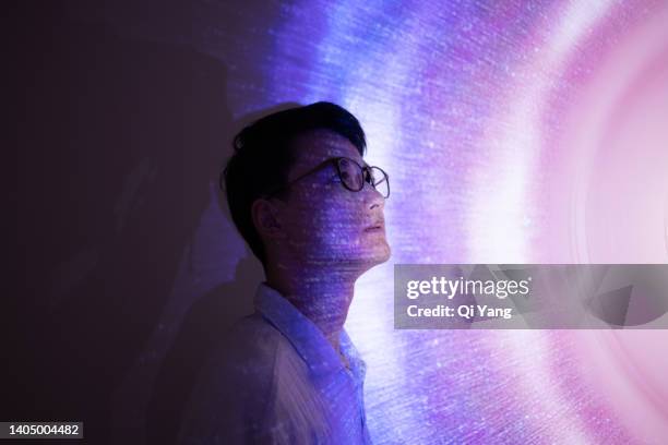 asian man standing on holographic background - medizin zukunft stock-fotos und bilder