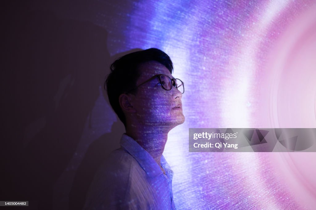 Asian man standing on holographic background