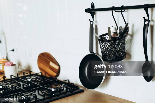 kitchen stove, pan and basket with crockery above table with stovetop. - metal kitchen worktop stock pictures, royalty-free photos & images