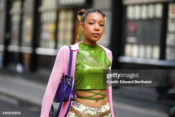 Guest wears gold hair fringed hair clips, a green ribbed shiny high neck / cropped / laces waist t-shirt, a pale pink long kimono, gold bracelets,...