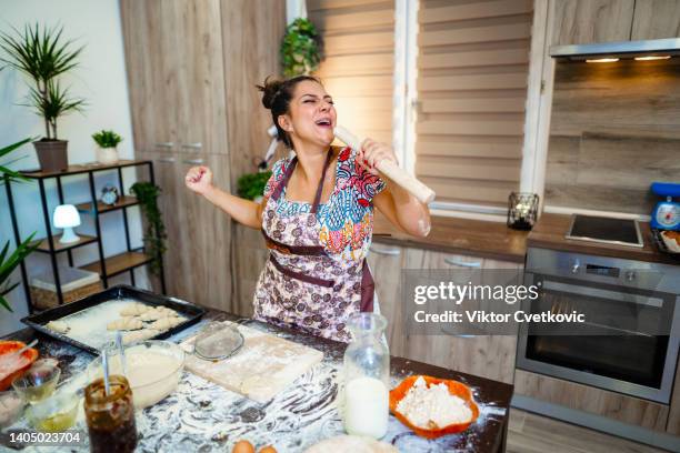 woman having fun while kneading pastry in the kitchen - messy cooking stock pictures, royalty-free photos & images
