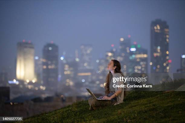 woman working on laptop outdoors in front of cityscape - israeli ethnicity bildbanksfoton och bilder