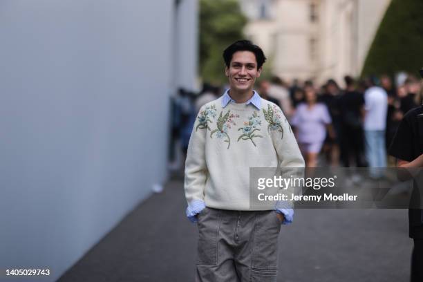 Chase Hudson seen wearing a blue striped shirt blouse, a creme beige floral embroidered knit pullover/sweater and a grey jeans denim cargo pants,...