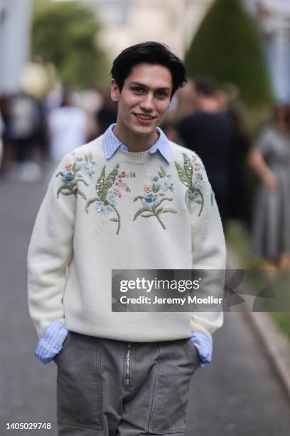 Chase Hudson seen wearing a blue striped shirt blouse, a creme beige floral embroidered knit pullover/sweater and a grey jeans denim cargo pants,...