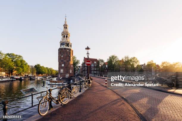 montelbaanstoren defence tower and canal in amsterdam, netherlands - amsterdam canal houses stock pictures, royalty-free photos & images