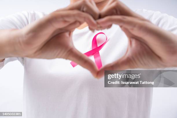 healthcare, medicine and breast cancer concept - woman with pink cancer ribbon - cancer awareness sign stock pictures, royalty-free photos & images