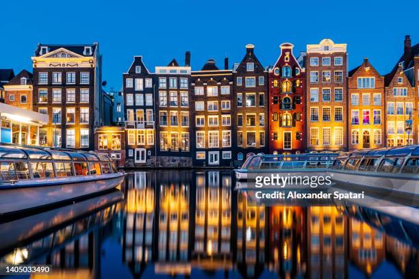 traditional dutch canal houses reflecting in the canal at dusk, amsterdam, netherlands - amsterdam dusk evening foto e immagini stock