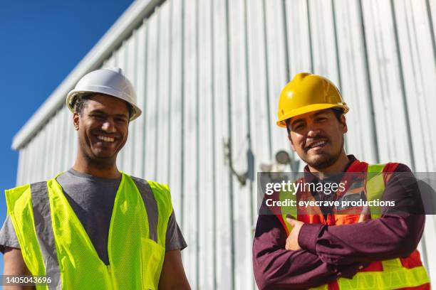 black and hispanic male construction workers on work site wearing ppe evaluating and discussing projects infrastructure photo series - good foundation stock pictures, royalty-free photos & images