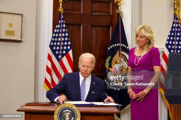 President Joe Biden signs the Bipartisan Safer Communities Act into law as first lady Jill Biden looks on in the Roosevelt Room of the White House on...