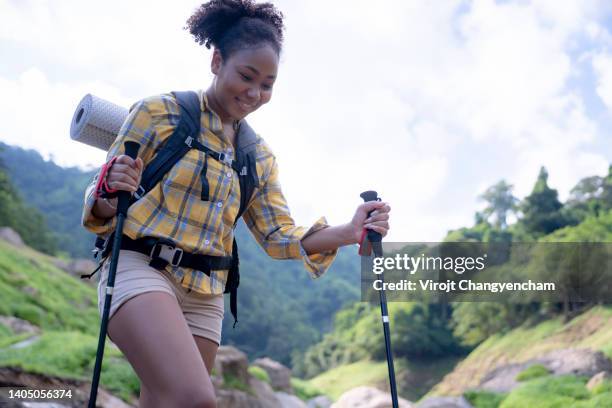 happy female hiking with trekking pole in the nature travel - hiking pole stock-fotos und bilder