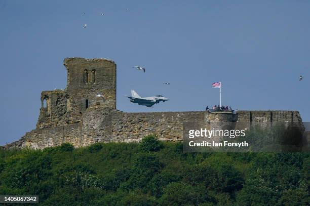 An RAF Typhoon flies over Scarborough castle as it performs on June 25, 2022 in Scarborough, England. Armed Forces Day is an annual opportunity for...