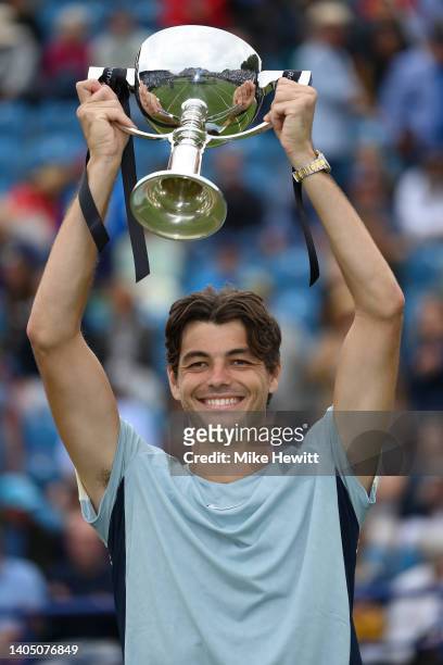 Taylor Fritz of The United States holds aloft the winner's trophy after his victory over Maxime Cressey of The United States in their Men's Singles...
