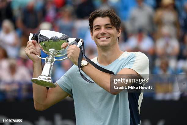 Taylor Fritz of The United States holds aloft the winner's trophy after his victory over Maxime Cressey of The United States in their Men's Singles...