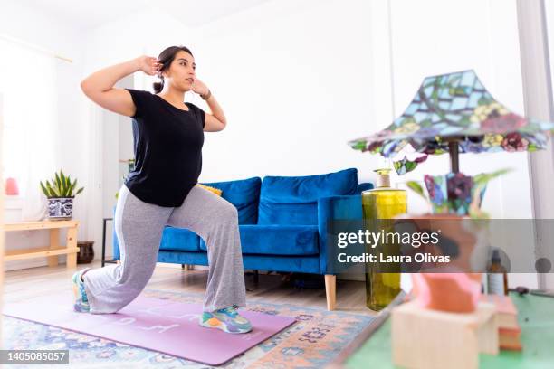 young adult woman exercising in her apartment - affondo foto e immagini stock