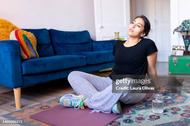 young adult woman sitting tired with her head tilted back after a workout - sitting on floor fotografías e imágenes de stock