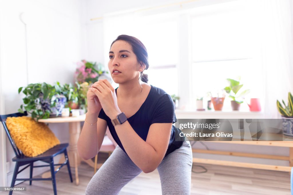 Young Adult Woman Exercising In Her Apartment