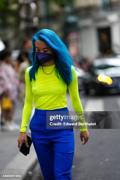 Guest wears a gold chain necklace, a neon yellow long sleeves t-shirt, royal blue high waist wide legs pants, outside the Comme des Garçons Homme...