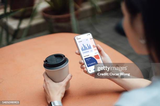 over the should view of young woman using smart phone at sidewalk cafe - designer coffee table stock pictures, royalty-free photos & images