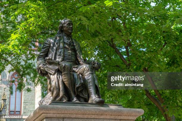 statue of benjamin franklin in front of college hall of upenn - penn stock pictures, royalty-free photos & images