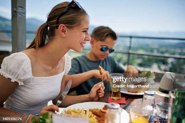 family enjoying traditional austrian wiener schnitzel lunch at a restaurant - austrian culture stock pictures, royalty-free photos & images