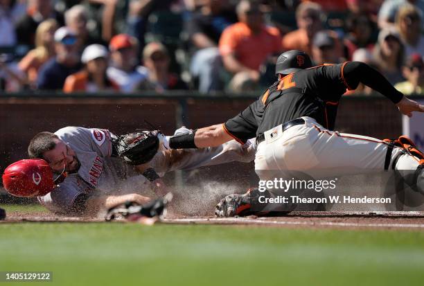 Mike Moustakas of the Cincinnati Reds scores sliding past the tag from Austin Wynns of the San Francisco Giants in the top of the second inning at...