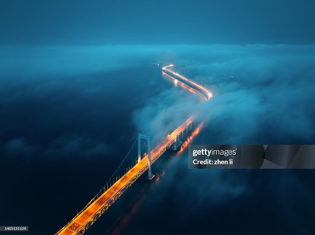 A cross-sea bridge in the fog at night