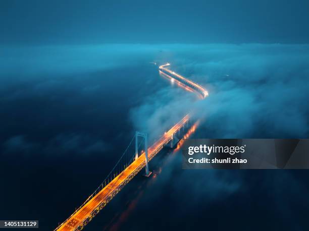 a cross-sea bridge in the fog at night - dark sky - fotografias e filmes do acervo