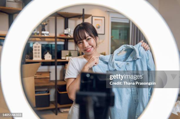 young female blogger recording an unboxing video - nebenjob stock-fotos und bilder