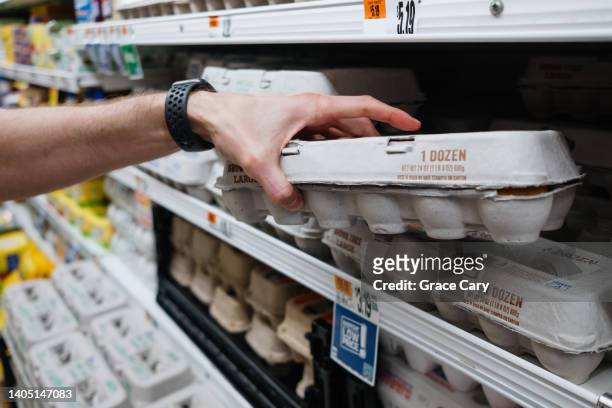 man grabs carton of eggs at supermarket - eierdoos stockfoto's en -beelden